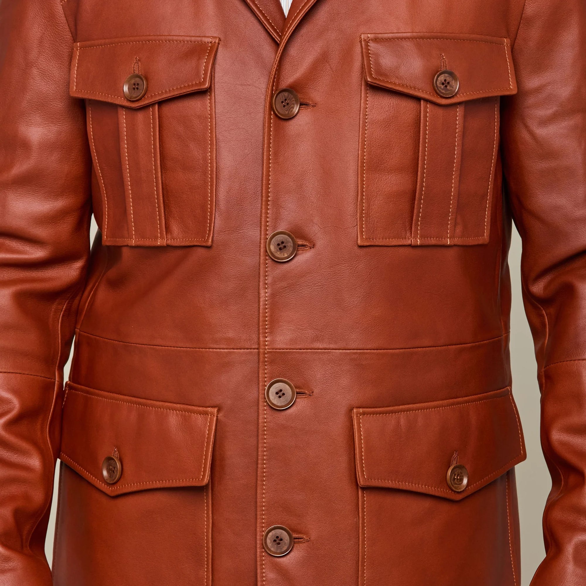 Picture of a model wearing our Leather cargo Jacket, brown color, close up front view showing all 4 pockets.