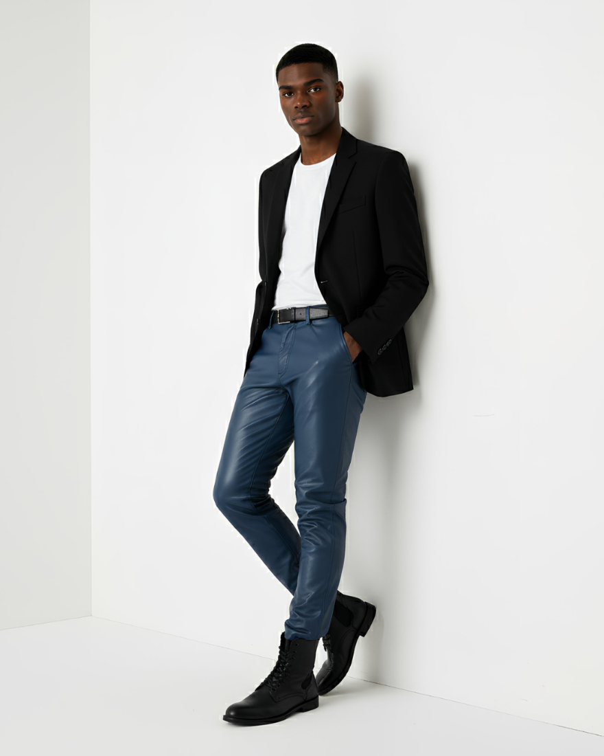 Man wearing our Mens Blue Leather Pants with a white tee and black jacket leaning against a white wall.