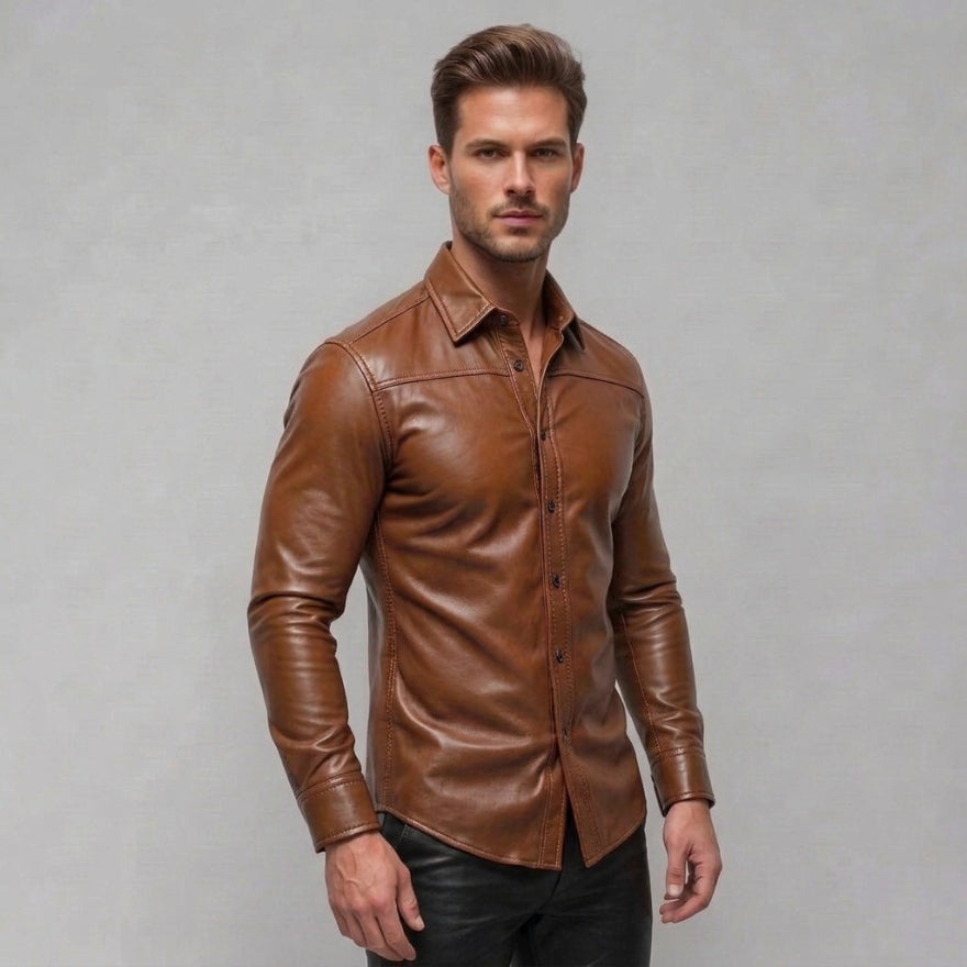 A man wearing our mens tan leather button-up shirt with a pointed collar and long sleeves, paired with black pants, standing against a plain light gray studio background, side view.