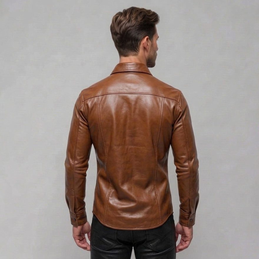 A man viewed from the back wearing our mens tan lather shirt and black pants, standing against a plain light gray studio background, back view.