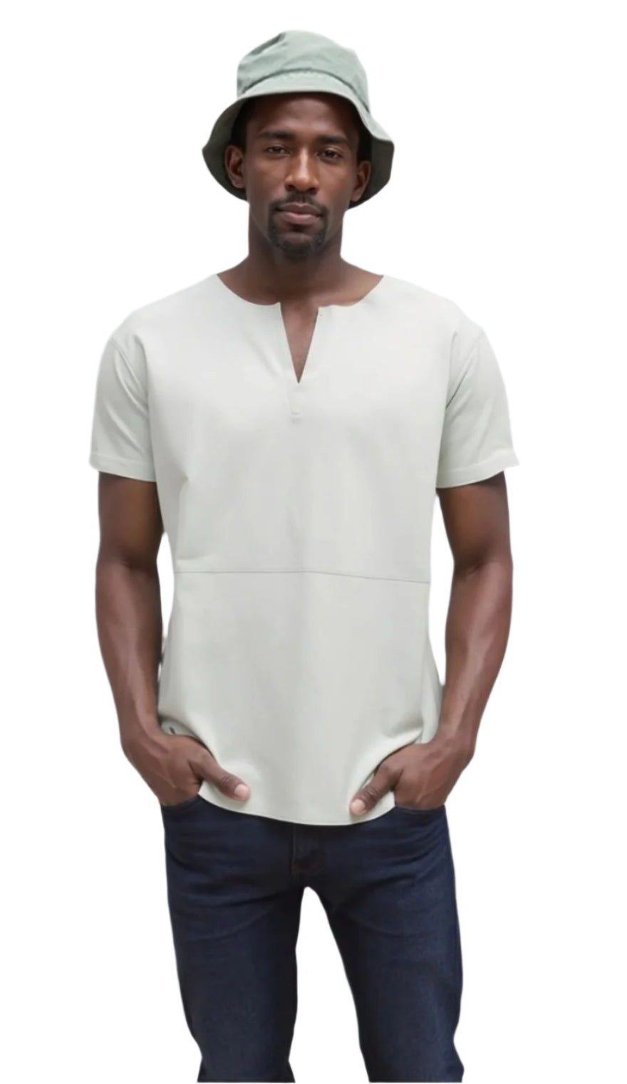 Man wearing a white leather Tee shirt, dark pants, and a green bucket hat against a plain background