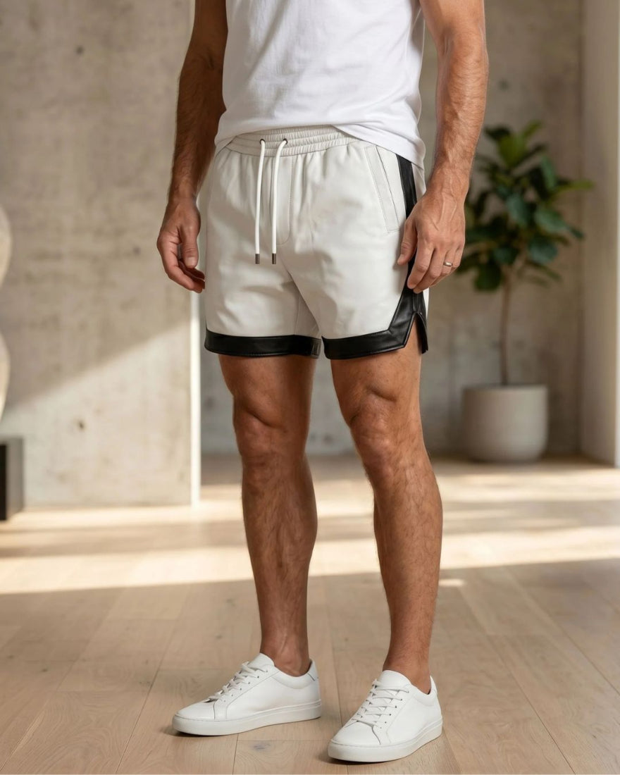 Person wearing our white leather shorts with black trim and white sneakers in a minimal indoor setting.