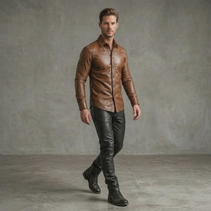 A man modeling mens tan leather long-sleeve button-up shirt paired with black leather pants and boots, walking down a fashion show runway.